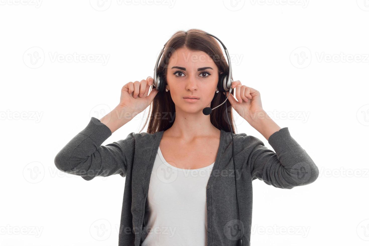 serious young call center office girl with headphones and microphone looking at the camera isolated on white background photo