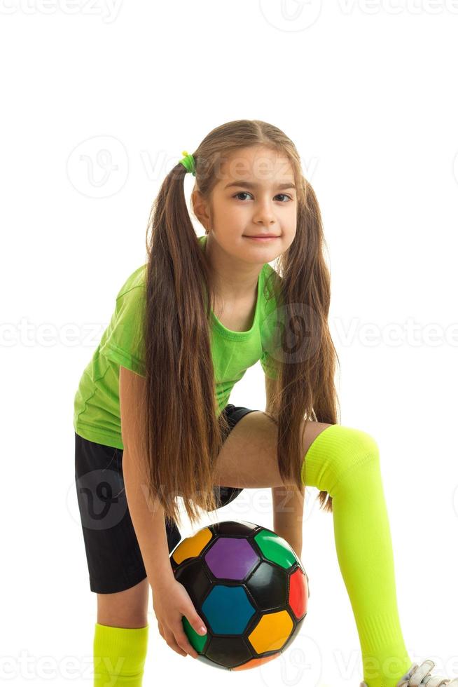 vertical of little school girl with color soccer ball in hands photo