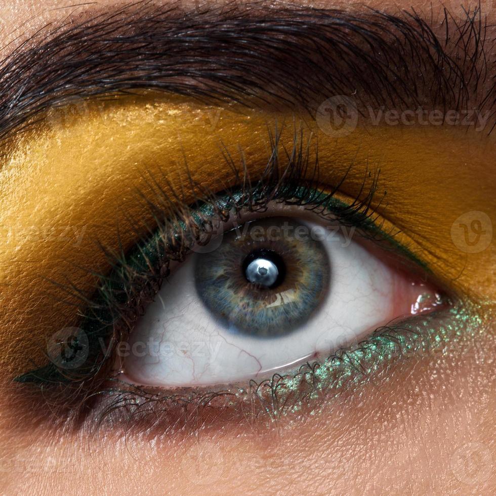 Macro woman eye with yellow makeup photo