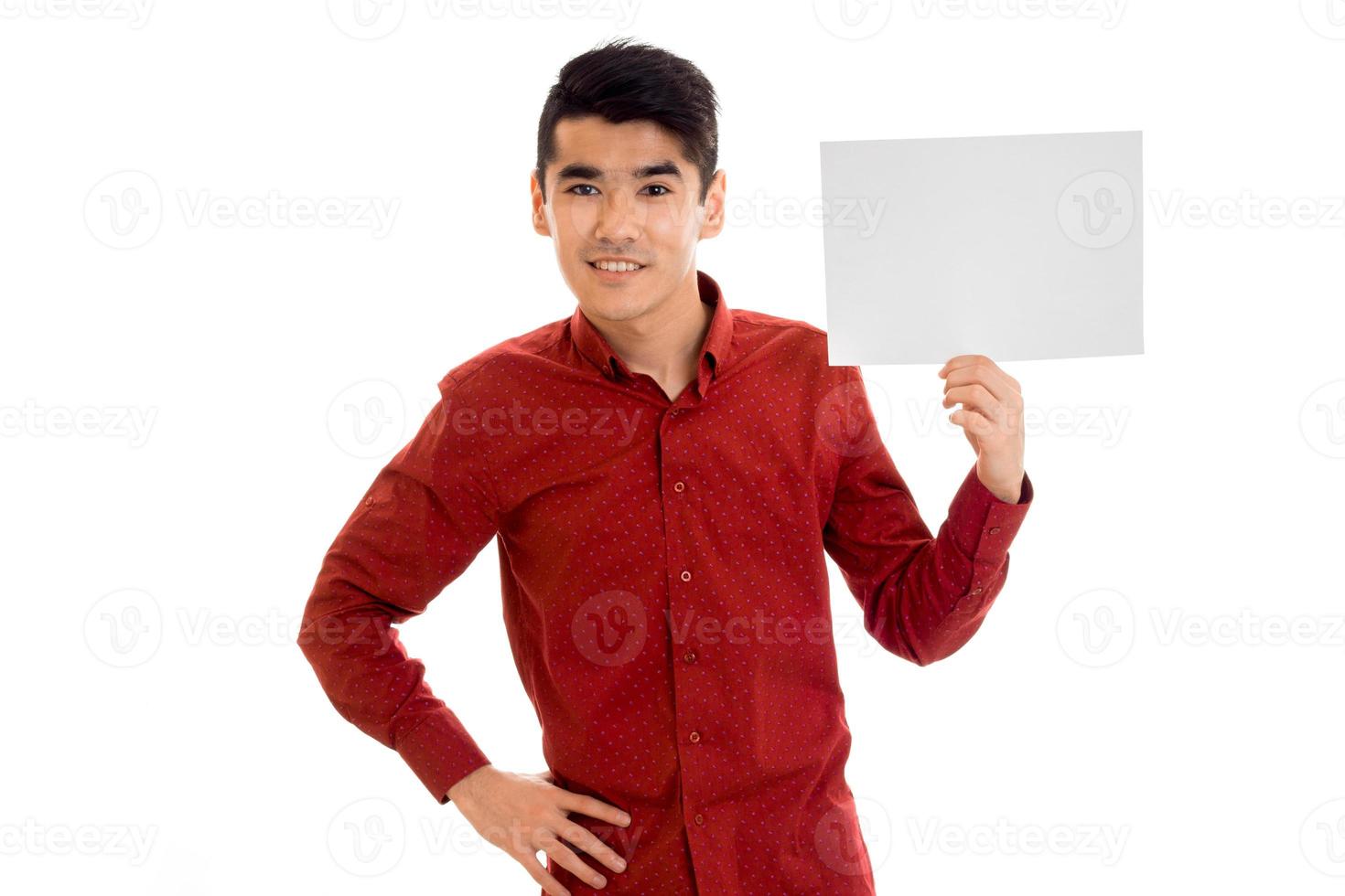 un joven con la camisa roja se ve bien y guarda una hoja de papel blanca foto