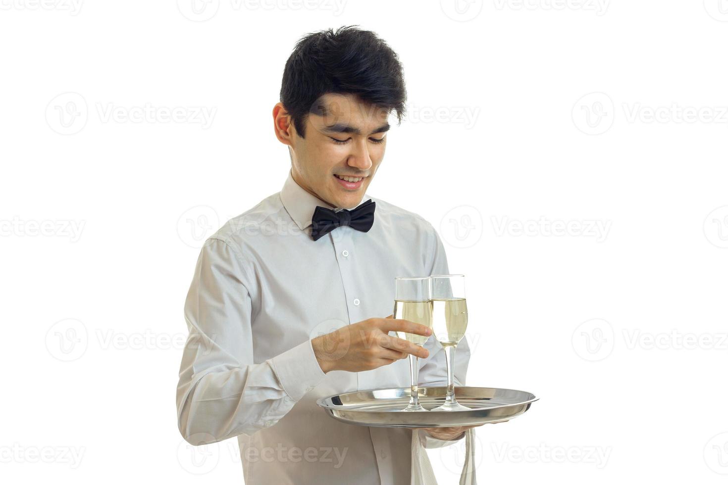 horizontal portrait of attractive smiling waiter who carries a tray with glasses of wine photo