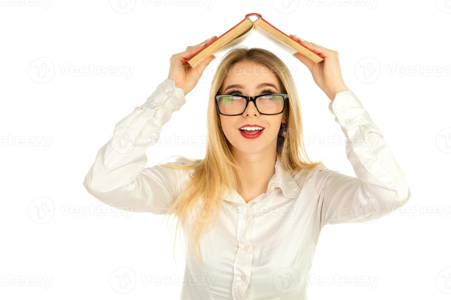 girl in glasses holding a book above the head photo