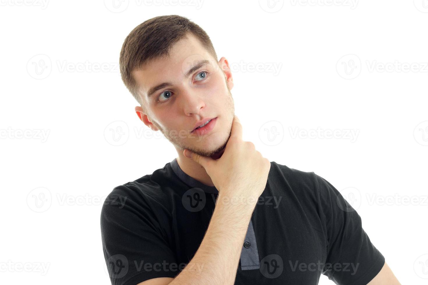 handsome young guy who keeps hand on Chin and looks toward photo