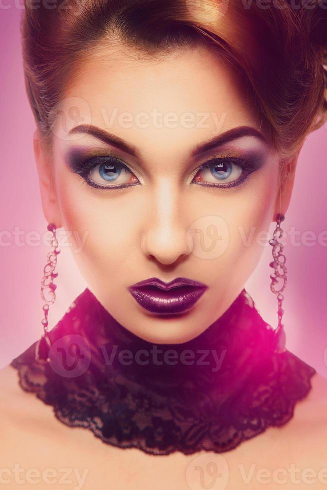 Serious high society person looking at camera with color make up photo