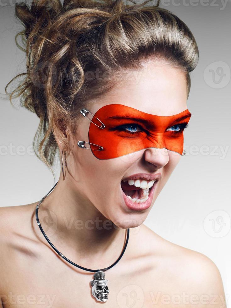 Girl in orange leather mask screaming photo