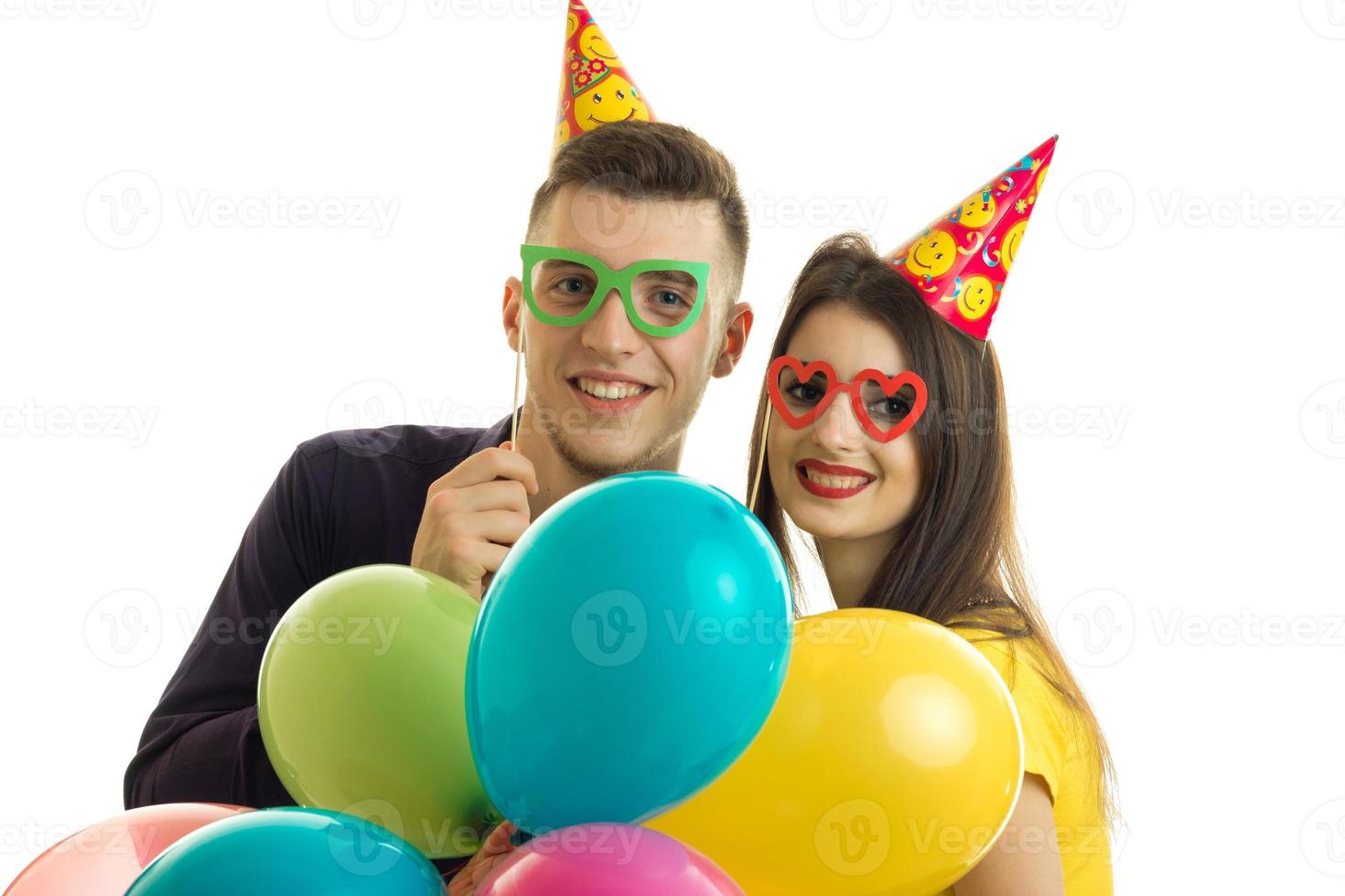 un retrato de primer plano de un chico y una chica alegres con gafas y globos foto