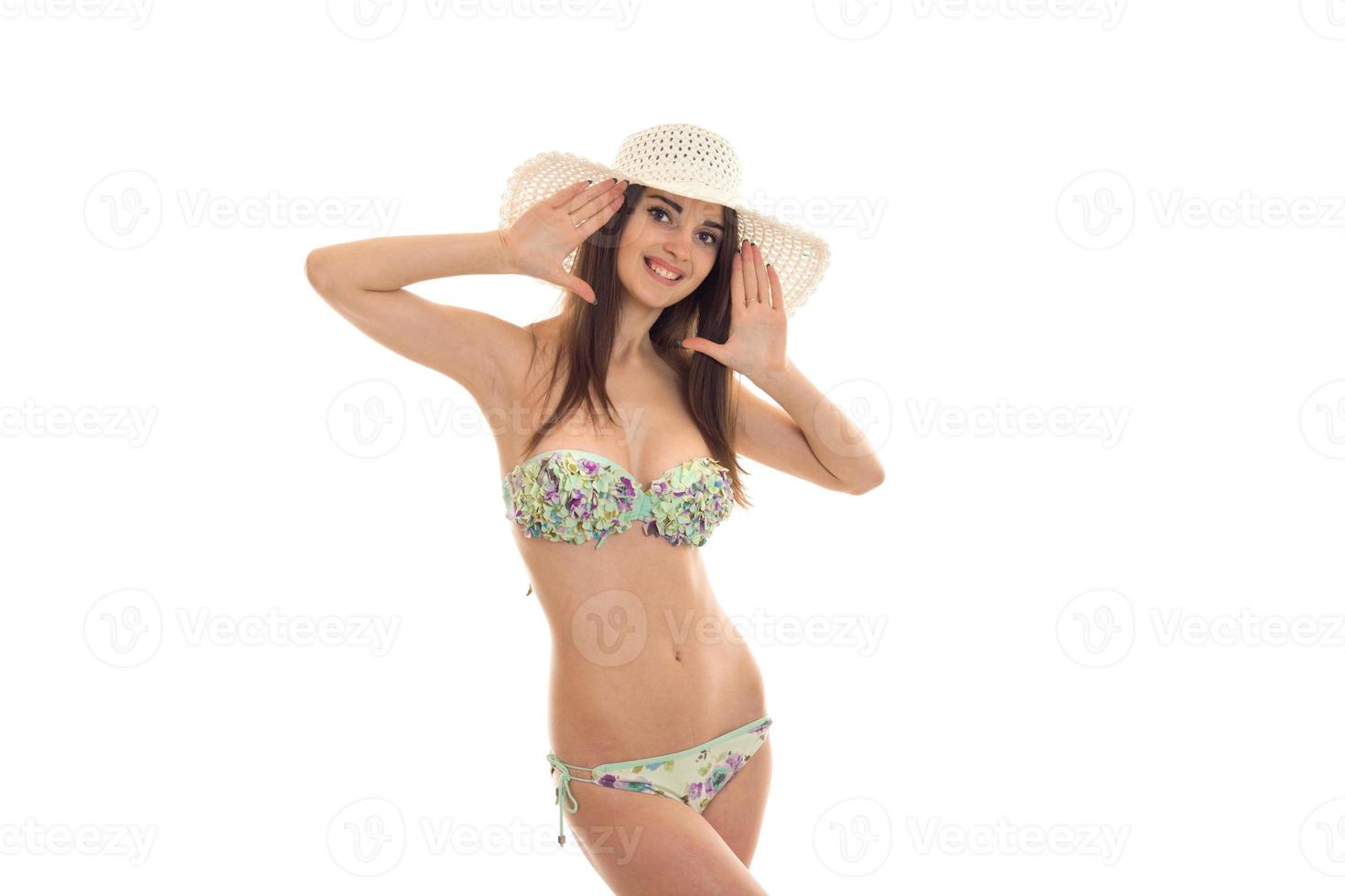sexy young girl in bathing suit holding hands hat on his head and smiling photo