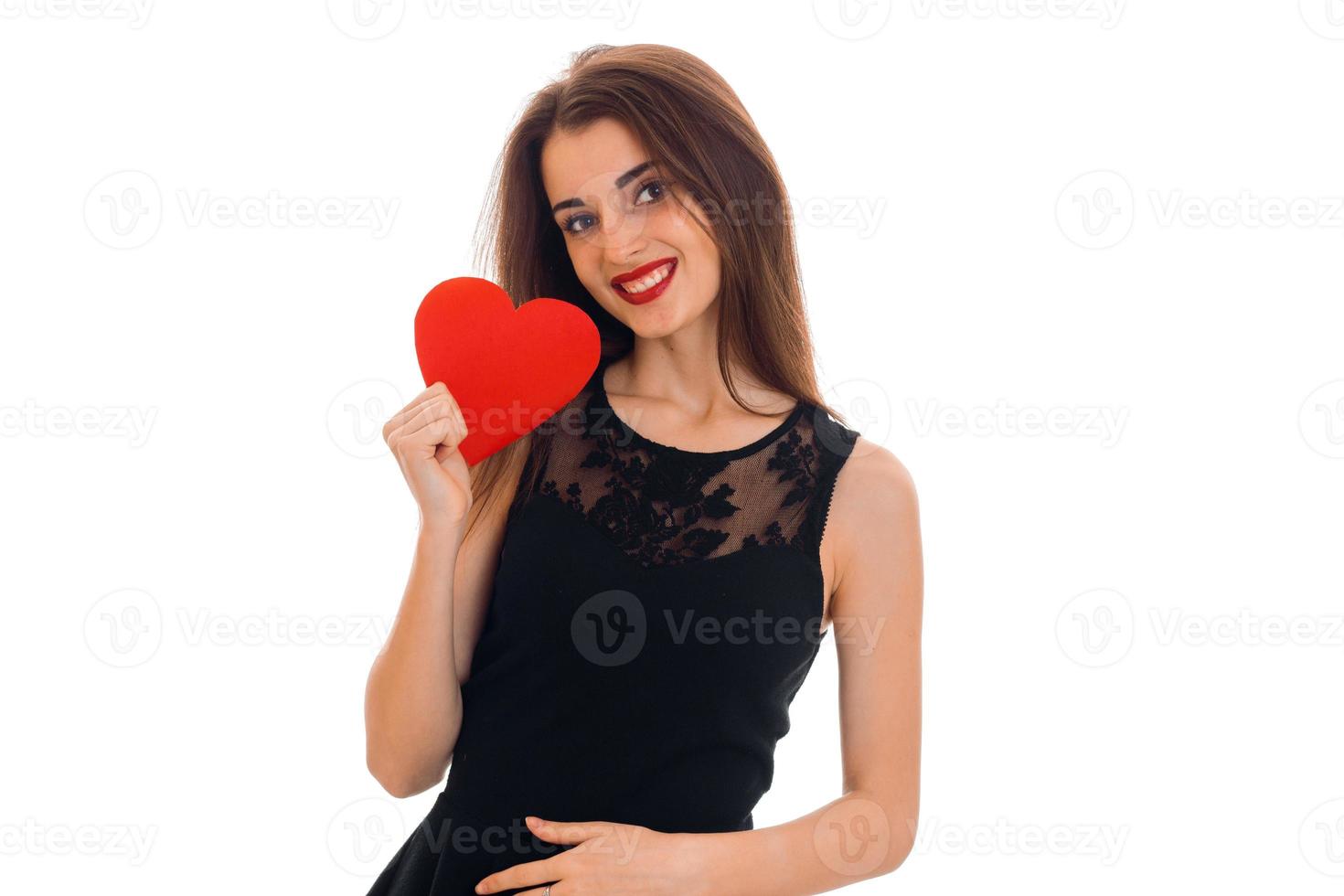 mujer joven y atractiva con labios rojos preparándose para celebrar el día de san valentín con el símbolo del corazón en el estudio aislado de fondo blanco foto