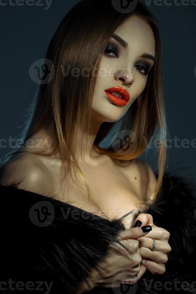 young attractive lady with red lips in fur coat looking at the camera photo