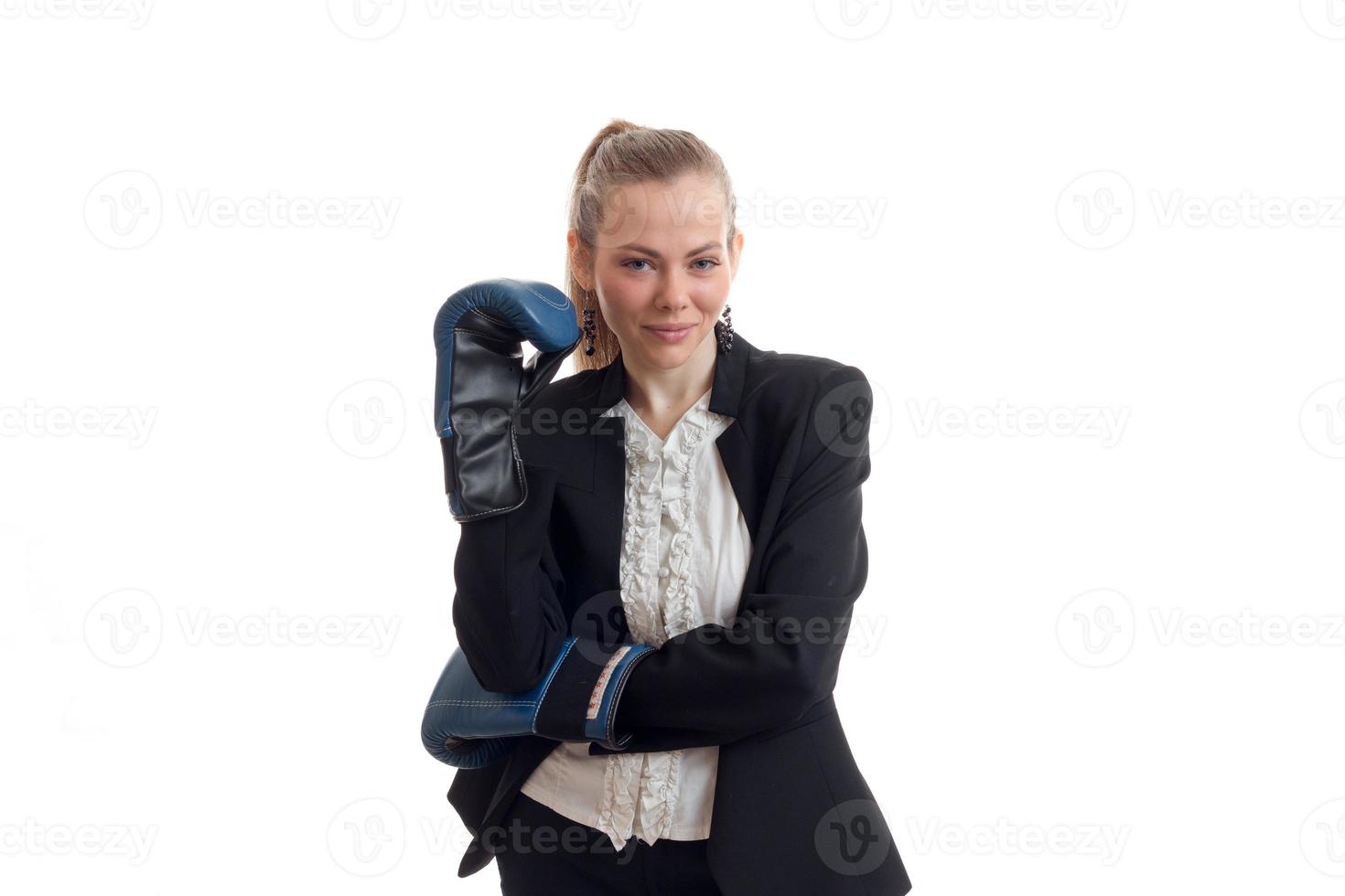 amazing young blonde in black suit stands in front of the camera holding hands in boxing gloves and smiling photo