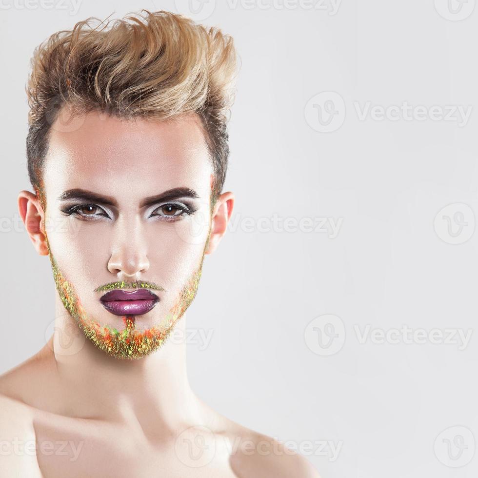 Close up portrait of beautiful man with healthy skin, makeup and multicolor beard photo