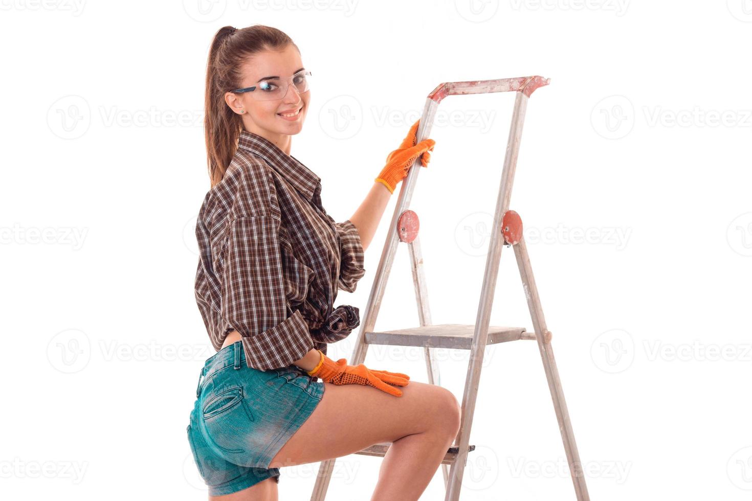 happy young girl in uniform makes renovation isolated on white background photo