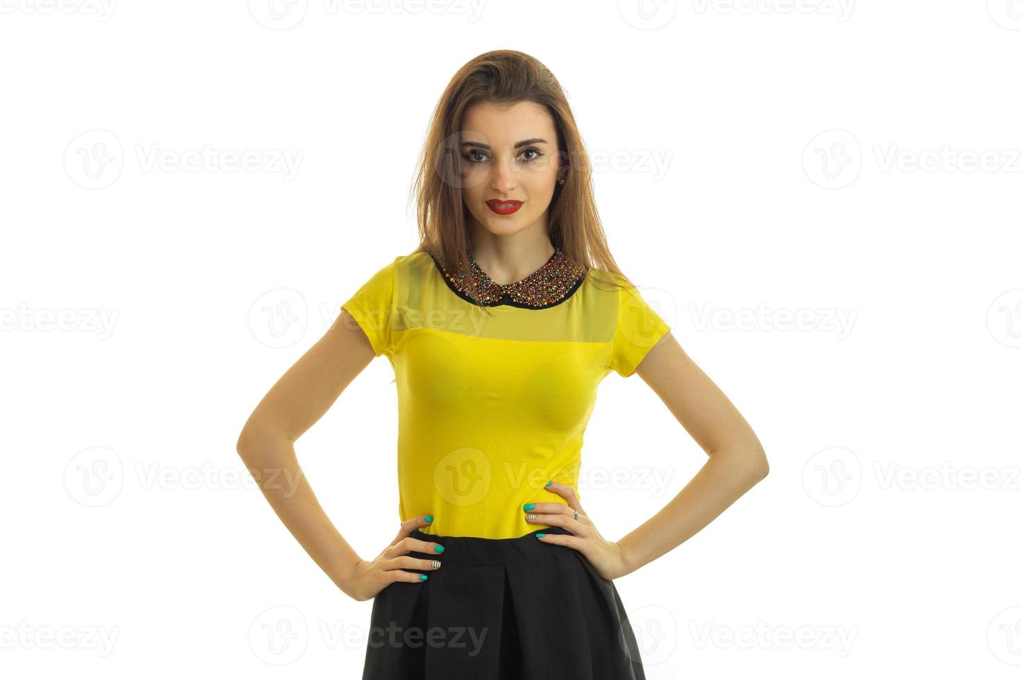young a wonderful girl in a bright jacket looks into the camera and keeps her hands on the sides photo