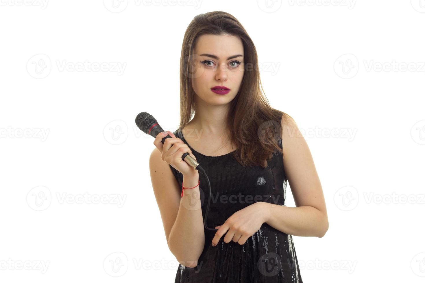 morena con vestido negro canta con micrófono foto