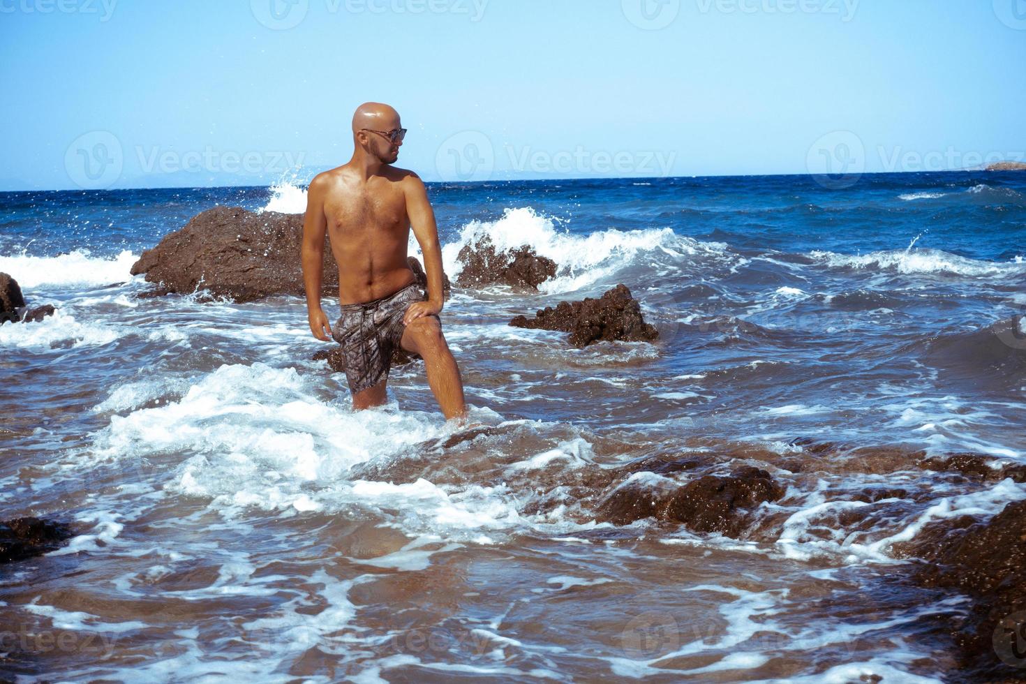 handsome young guy in the blue sea photo
