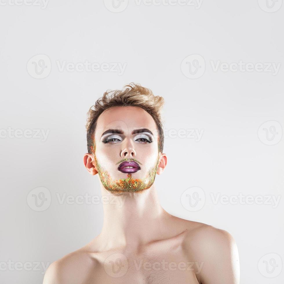 Square portrait of cutie young man with makeup and multicolor beard photo