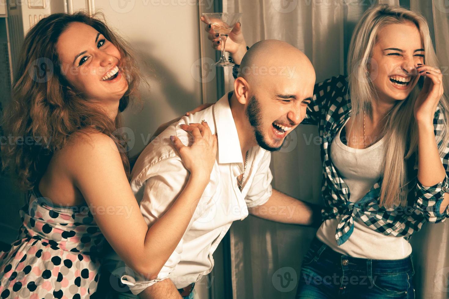 hombre con dos chicas encantadoras riéndose de una fiesta foto