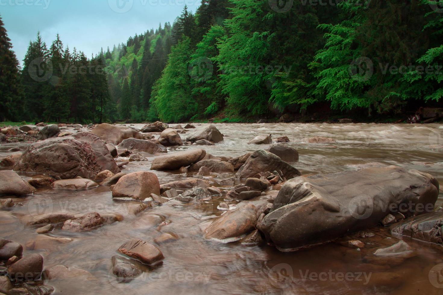 río tormentoso de montaña con fondo rocoso foto