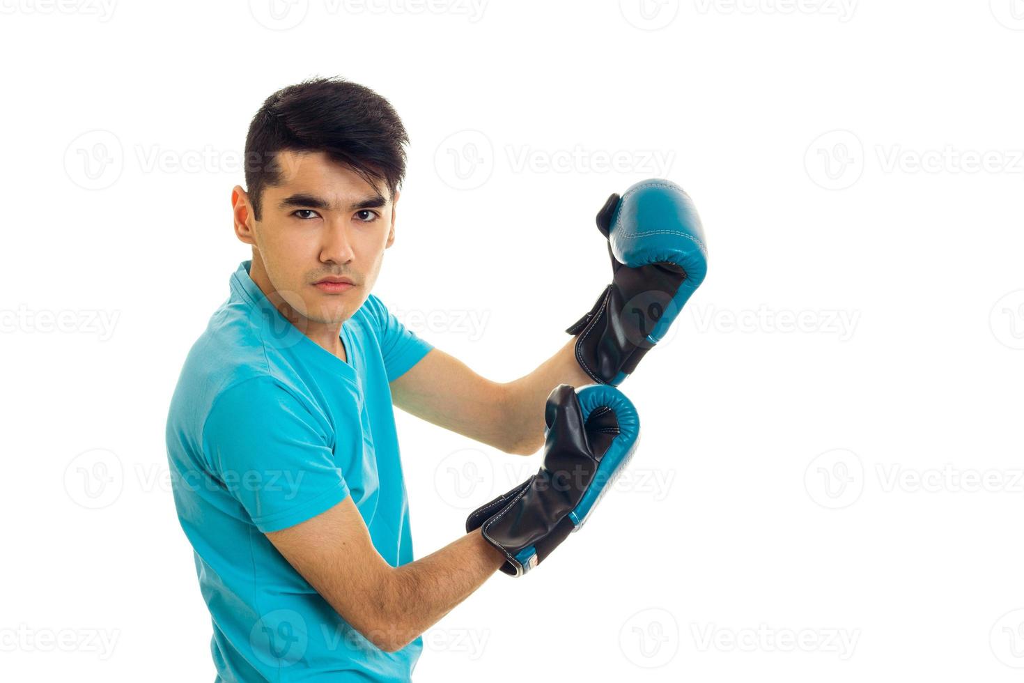 portrait of strong guy practicing boxing in blue gloves isolated on white background photo