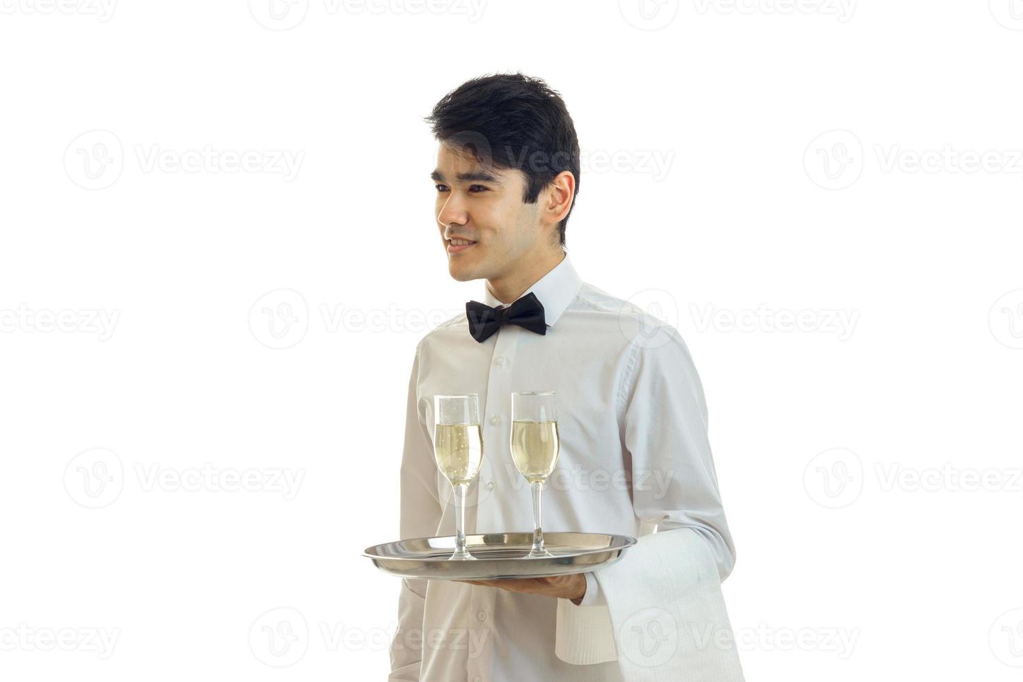 encantadora camisa de camarero sosteniendo una bandeja, y mira hacia foto