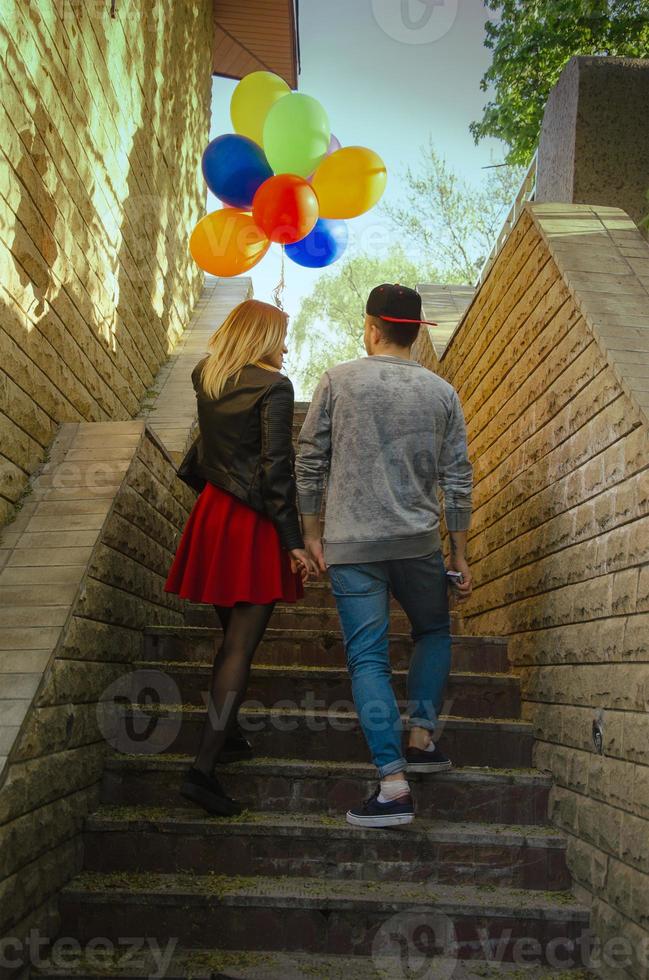 couple walks outdoors with balloons photo