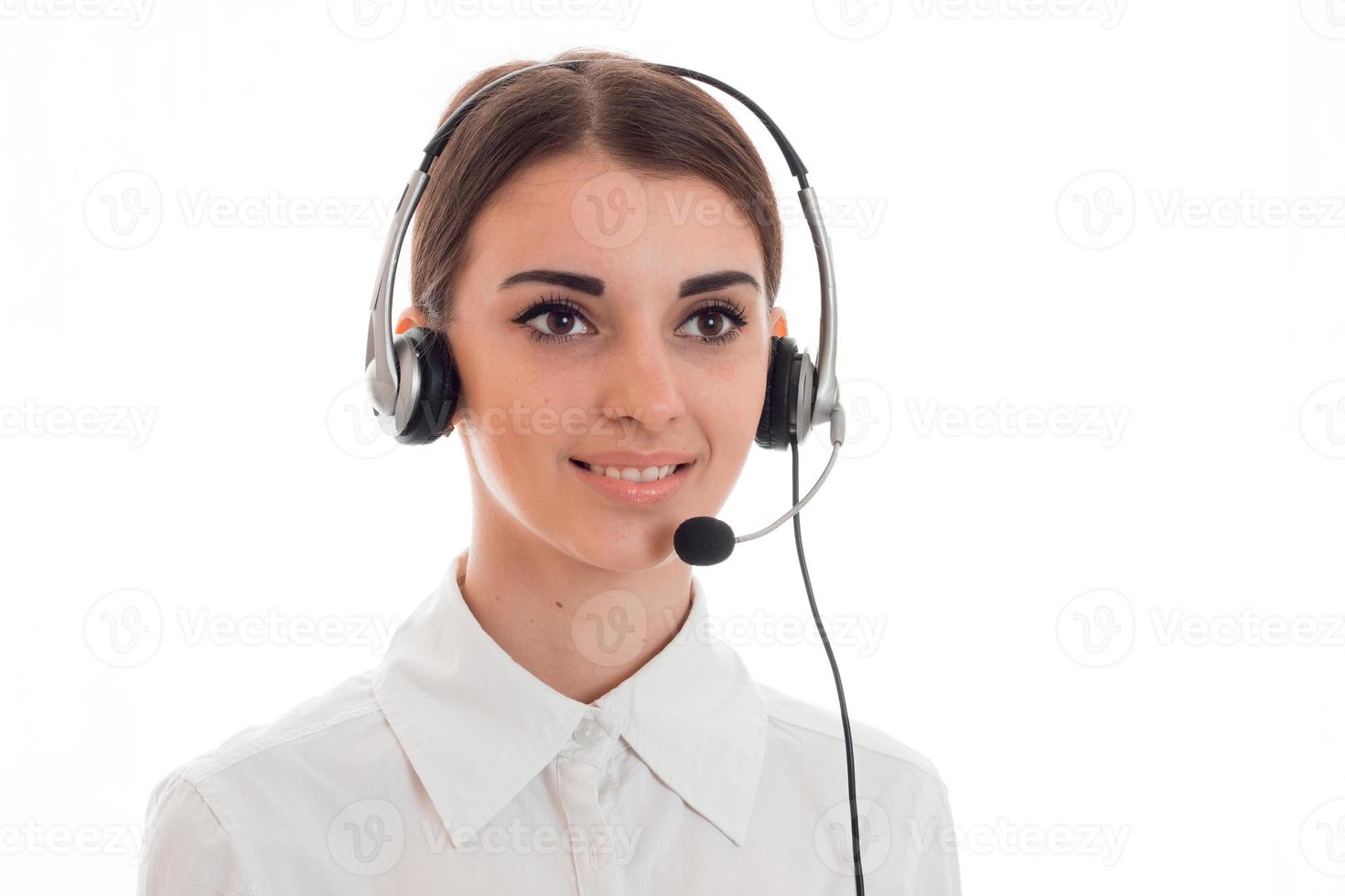 Portrait of a beautiful young girl in headphones with a microphone that looks into the distance and smiling photo