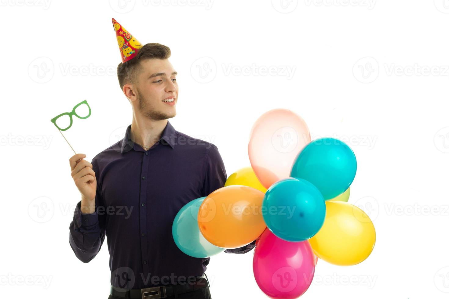 lovely young guy is smiling looks to the side and holding a paper glasses and air balls photo