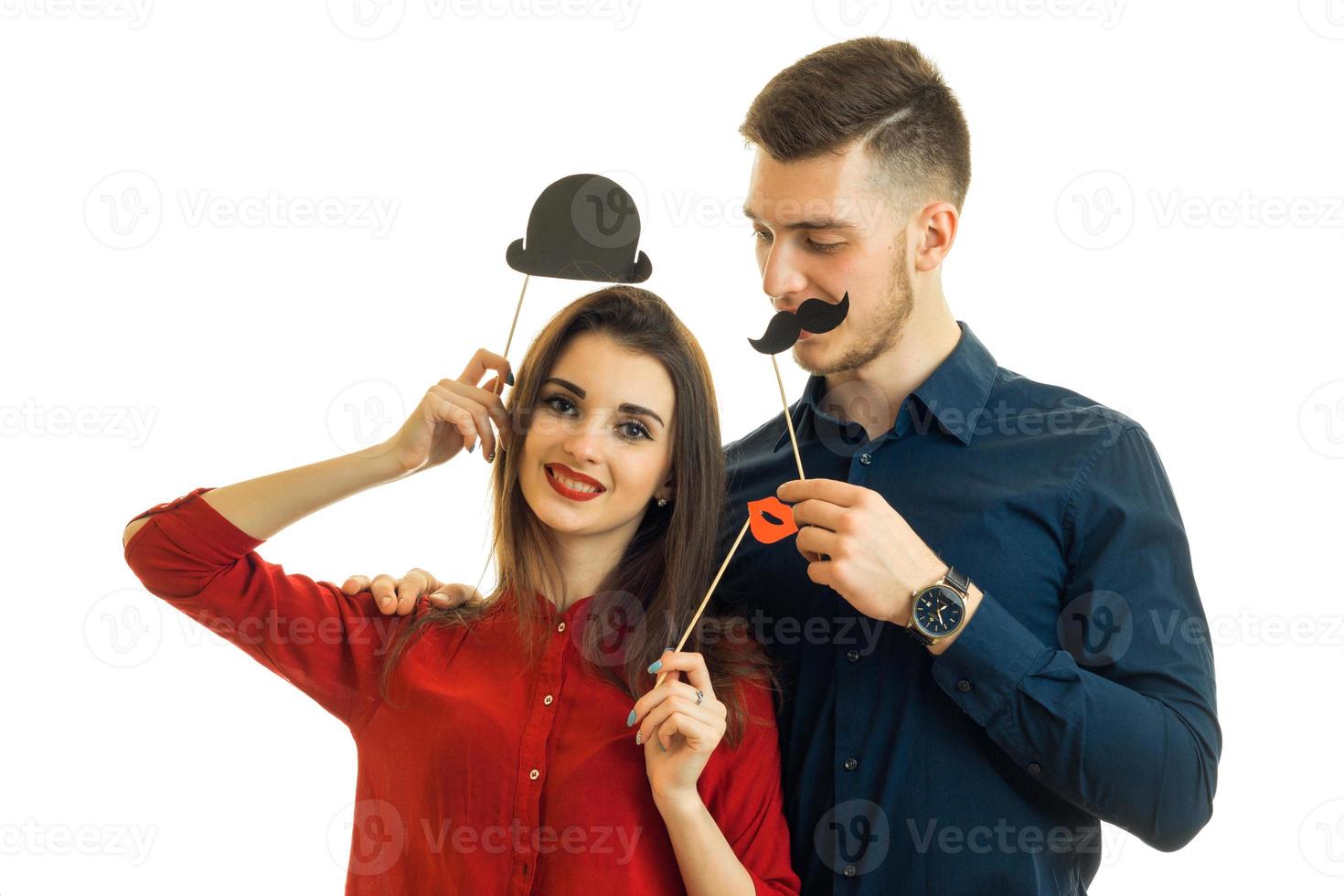 hermosa pareja joven sonriendo y llevando accesorios de papel para la foto