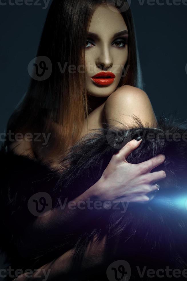 high society lady with red lips in fur coat looking at the camera photo