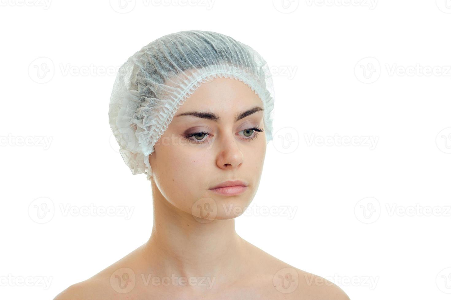 girl in a shower Cap looks down isolated on white background photo