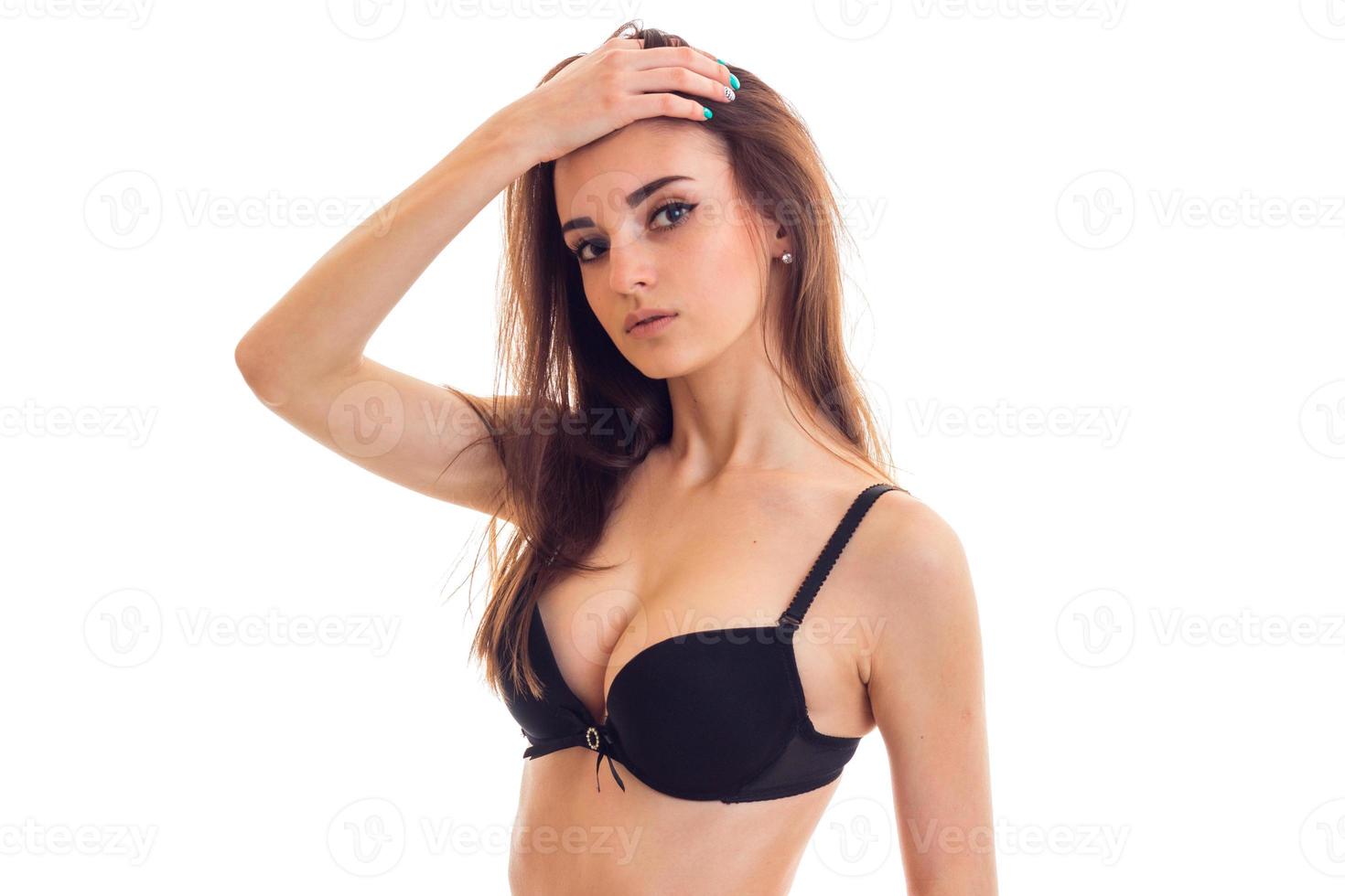 Portrait of a beautiful young girl with beautiful natural breasts in a black bra which has raised her hand to head and looks into the camera photo
