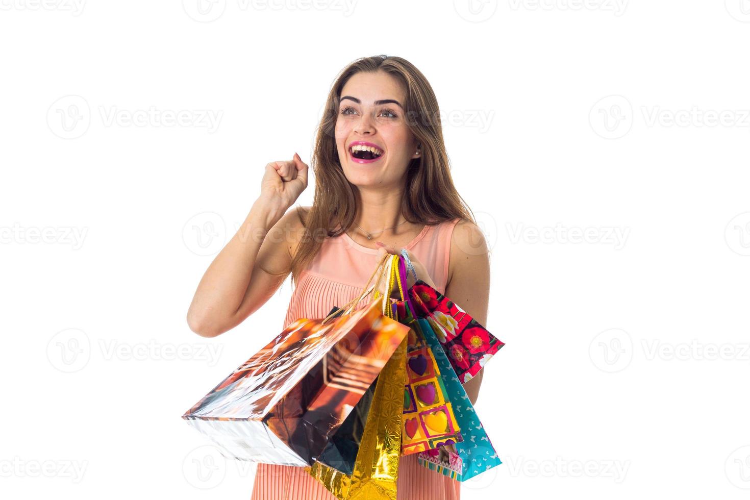 fun girl holding colorful packages with gifts is isolated on a white background photo