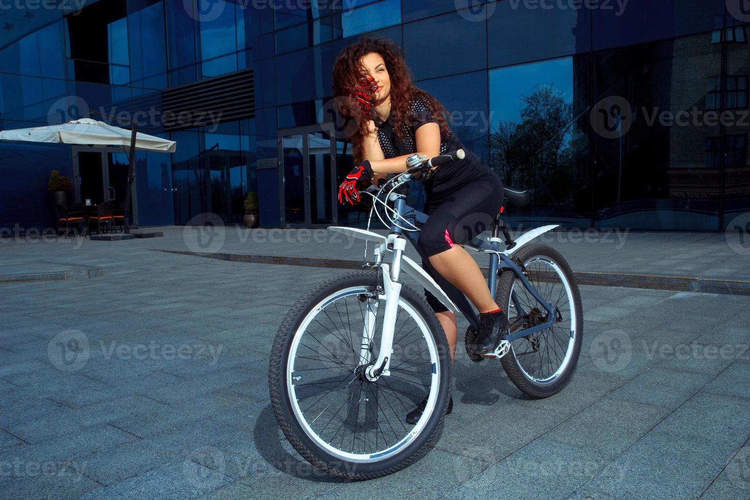 cheerful brunette sports woman on a bicycle photo