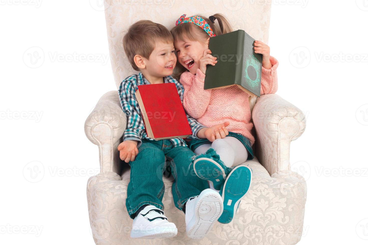 Children sit in a chair with books photo