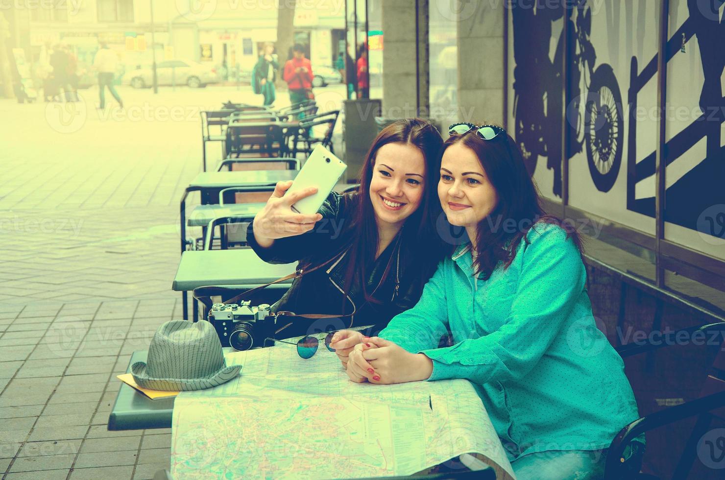 dos mujeres sentadas en una mesa en la calle foto