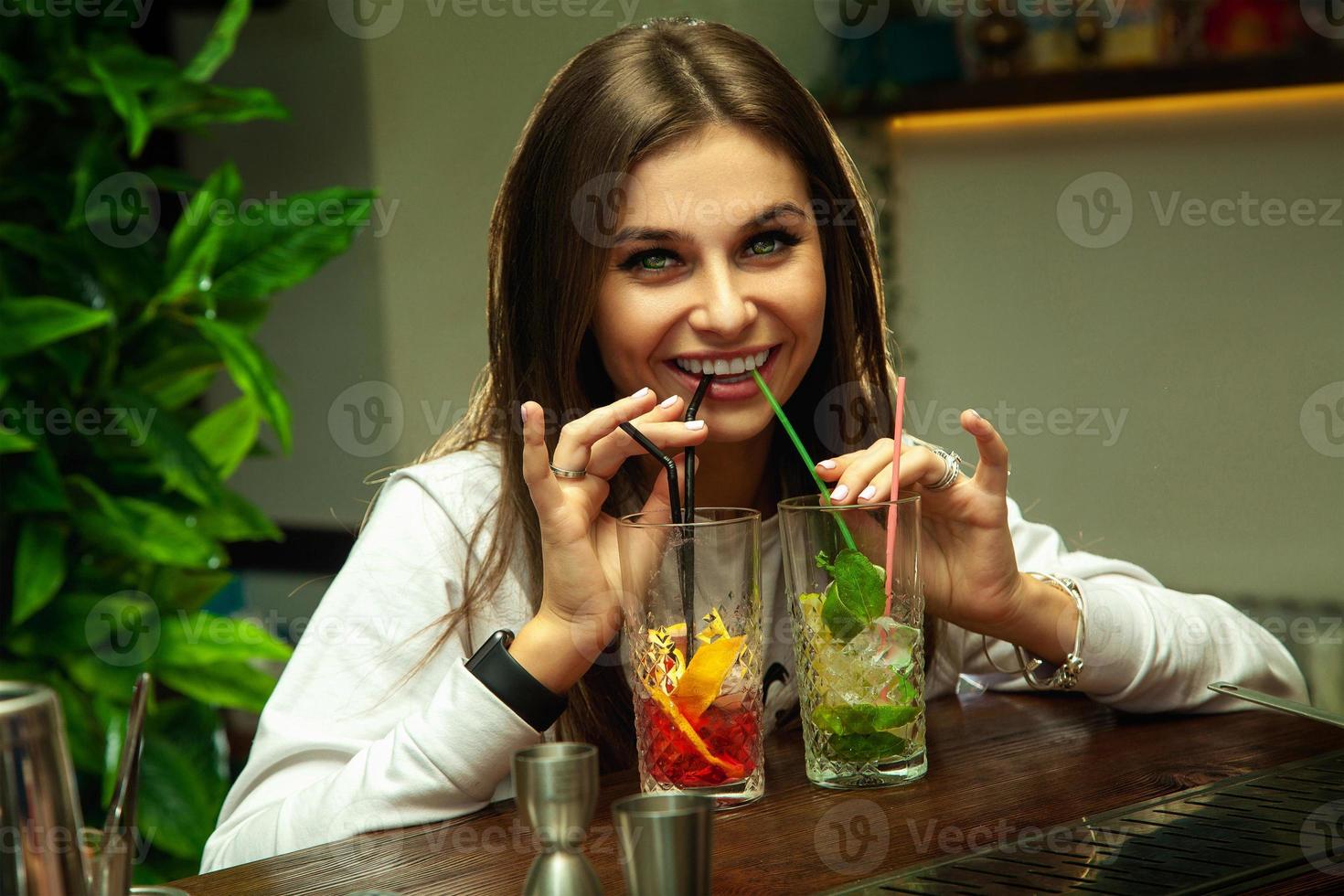 girl drinks two cocktails at the same photo