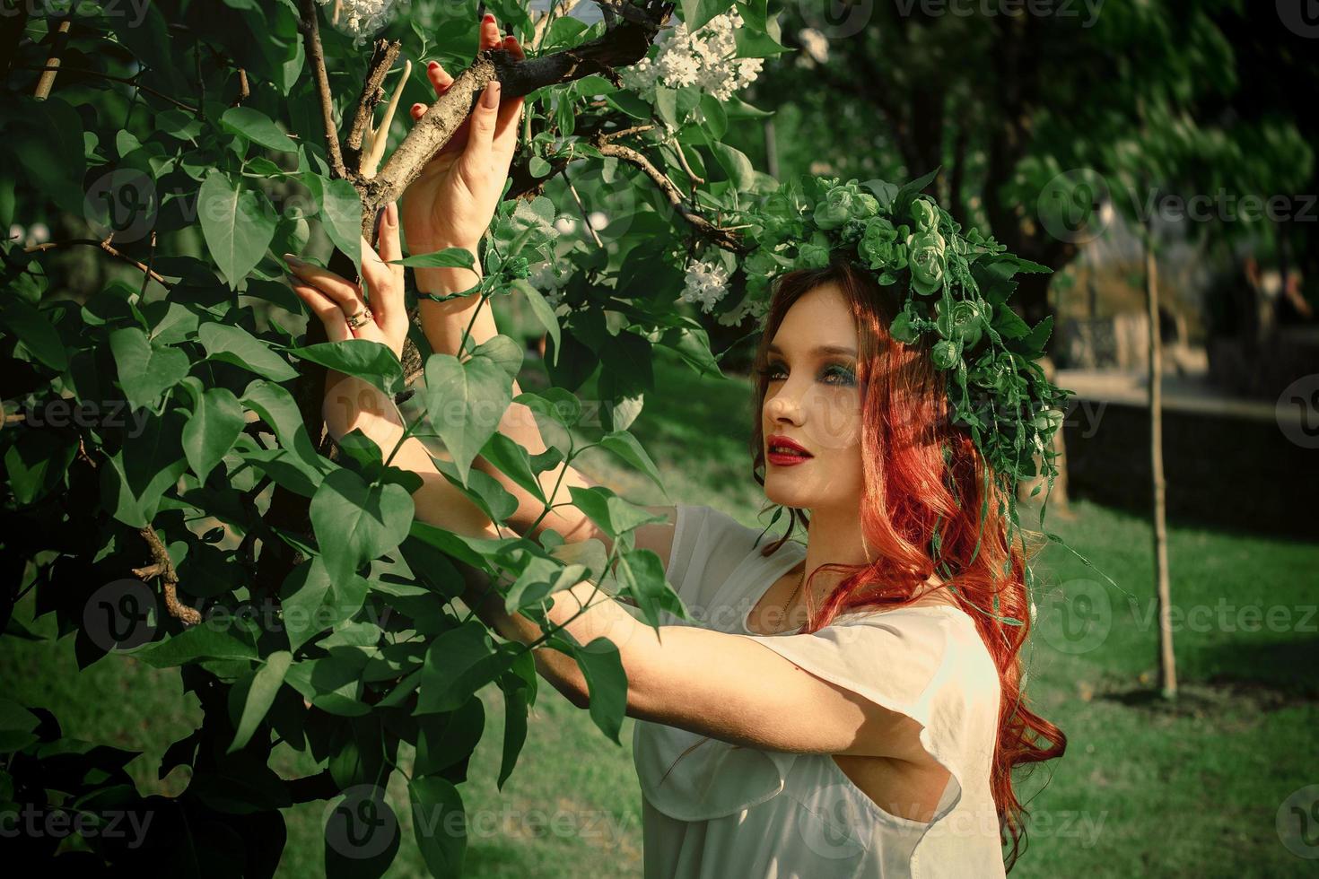 Attractive young girl with red hair and wreath on head photo