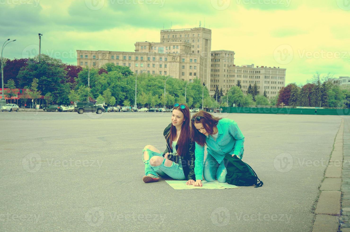 Tourists sitting on the pavement in the square photo