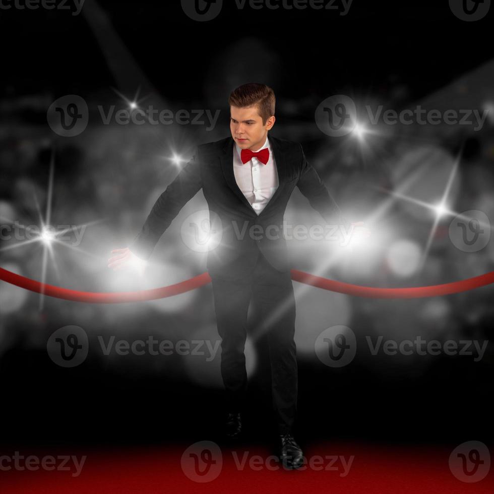 man in a suit on the red carpet and hiding from the paparazzi photo
