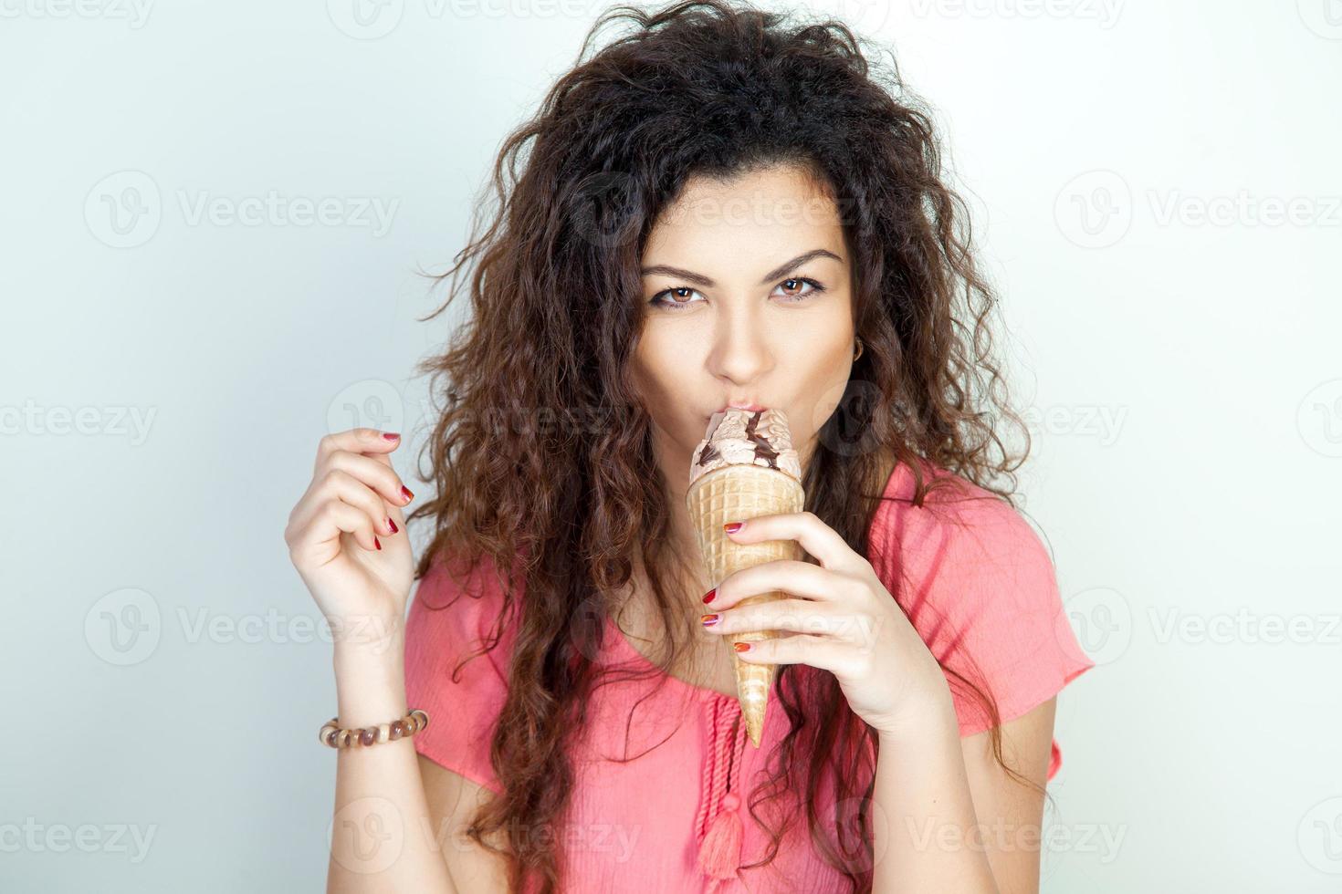 serious young woman eats ice cream cone photo