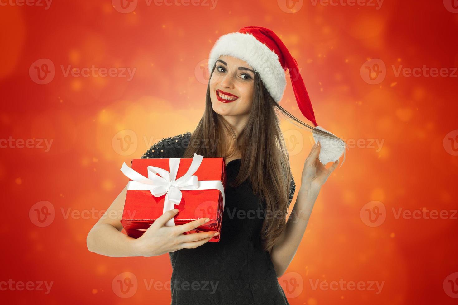 mujer joven con sombrero de santa con regalo rojo foto