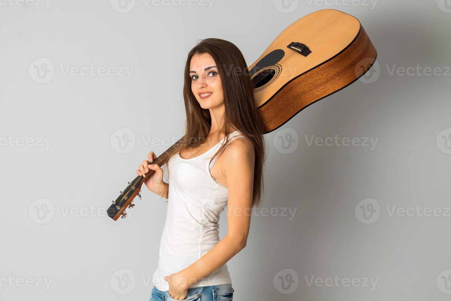 cheerful young woman with guitar in hands photo