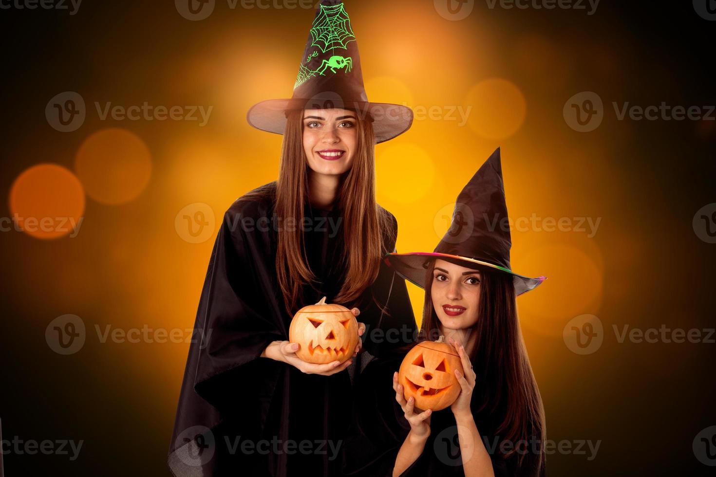 beautiful young women with pumpkins in hands photo