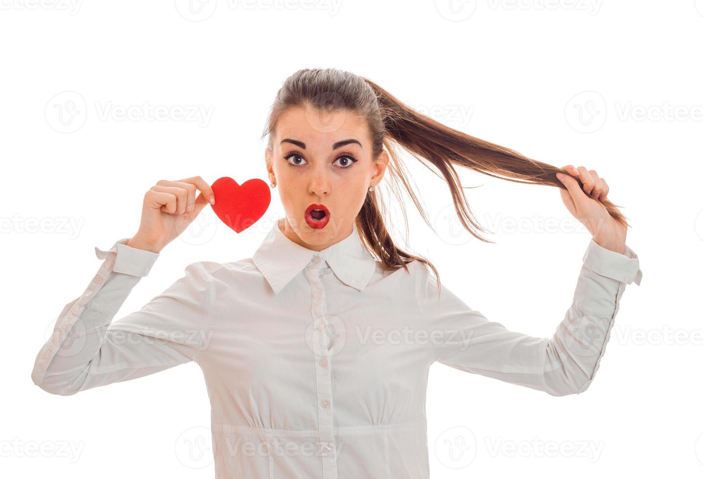 Valentine's day concept. Love . Young surprised girl with red heart isolated on white background in studio photo