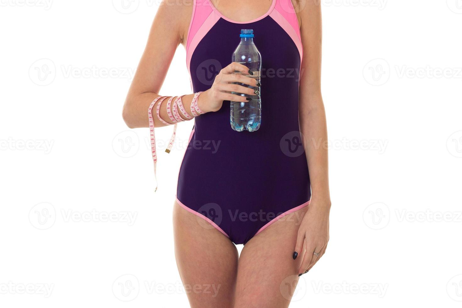 summertime portrait of young sexual lady in full length swimsuit with bottle  water and measure tape isolated on white background in studio photo