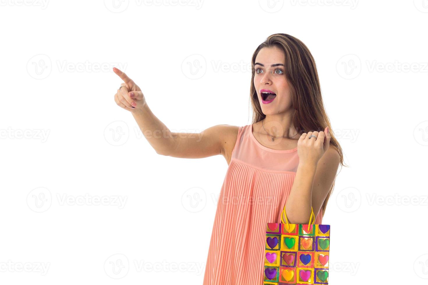 young girl reached out with surprise forward opened her mouth while the other hand holds the package izoliovano on a white background photo