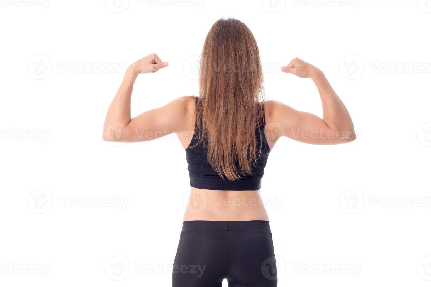 athletic young girl worth backwards and shows muscle on hand isolated  white background photo