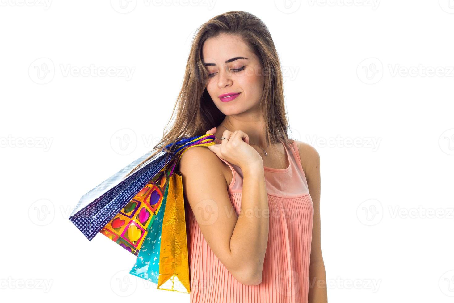 young girl lowered her eyes down and keeps the shoulder different colored bags isolated on white background photo