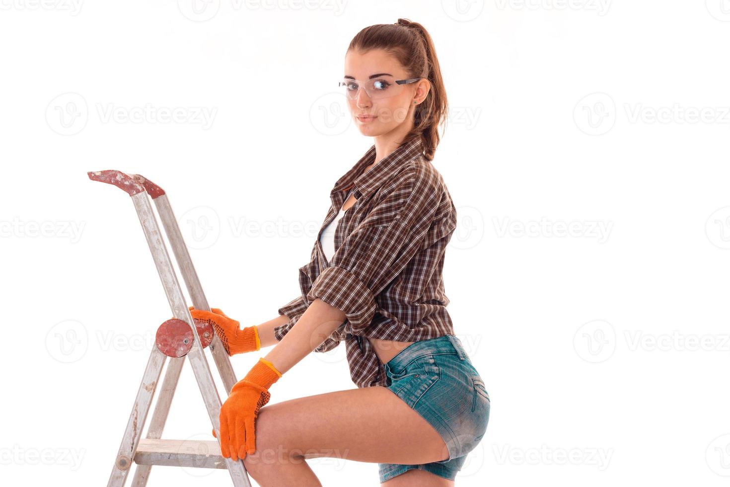 sexy brunette woman builder makes renovation isolated on white background photo