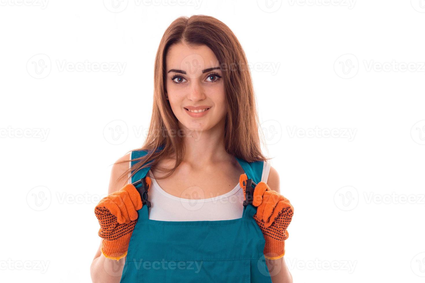 attractive brunette woman builder makes renovation and smiling on camera in uniform isolated on white background photo